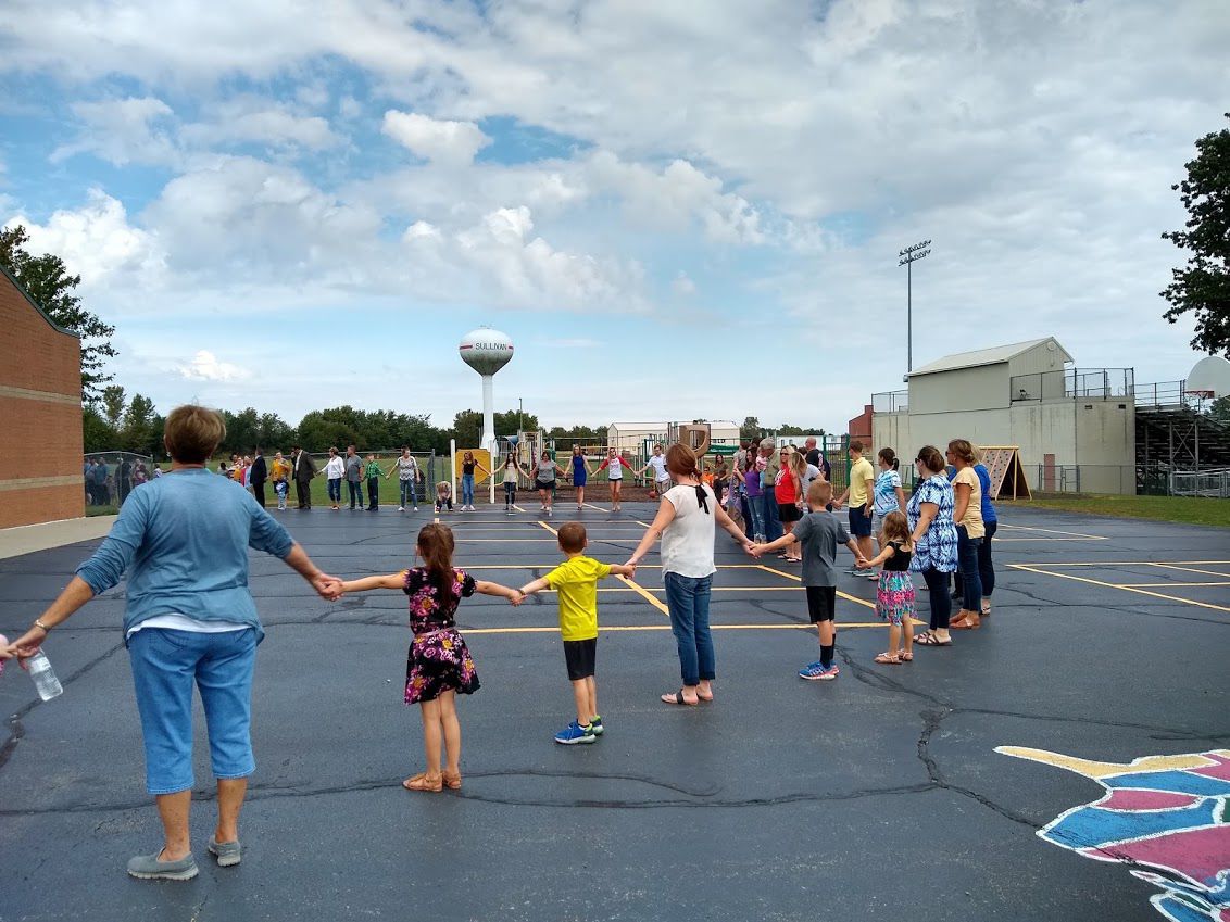 Linking hands, water tower backdrop